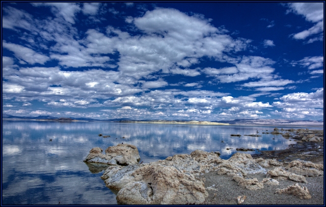Mono Lake shoreline.  THe small deposits of tufa seem to mirror the clouds in the sky and reflected in the calm water.